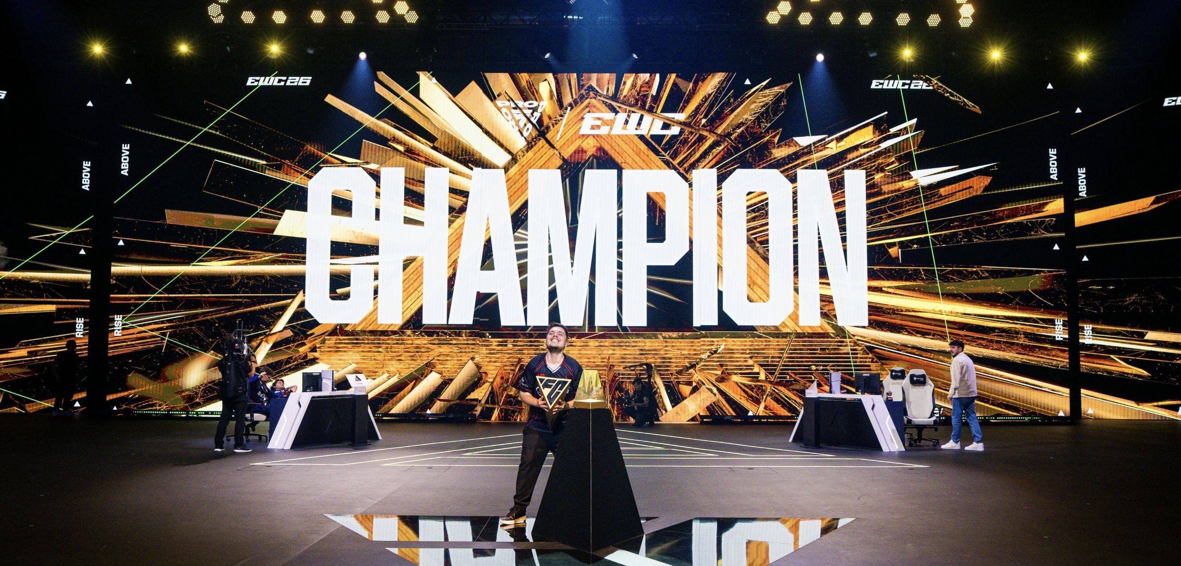 Główna scena Esports World Cup 2026 w Paryżu z napisem CHAMPION na ekranie i zawodnikiem w świetle reflektorów